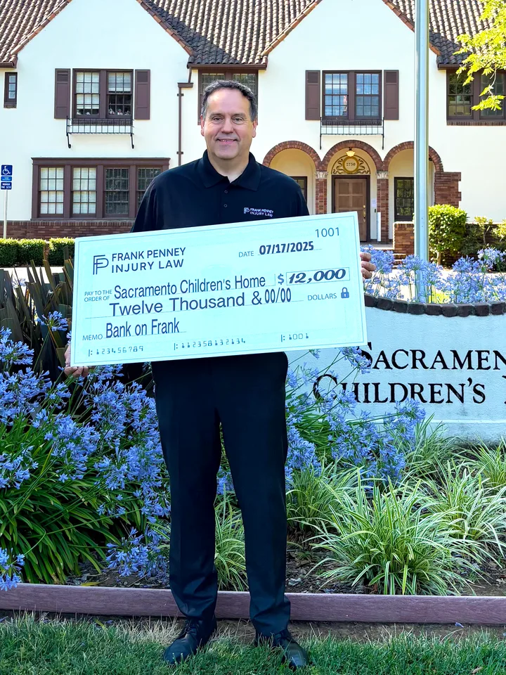 Frank Penney presenting a $12,000 donation check to the Sacramento Children's Home in July 2025